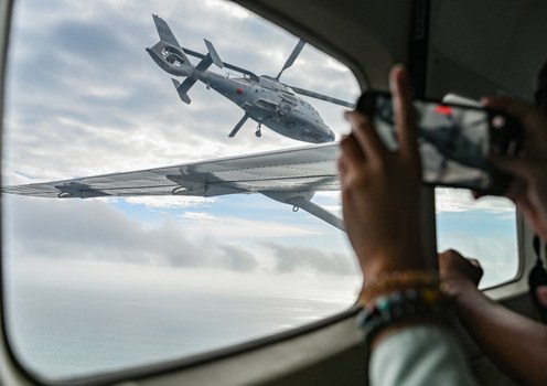 Journalists on a Philippine Bureau of Fisheries and Aquatic Resources aircraft take photos of a Chinese Navy helicopter over the Scarborough Shoal in the South China Sea, Feb. 18, 2025.